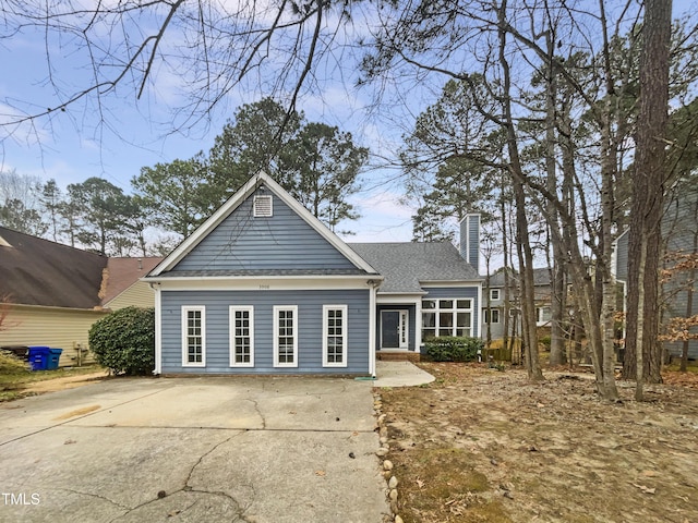 view of front of house featuring roof with shingles and a chimney