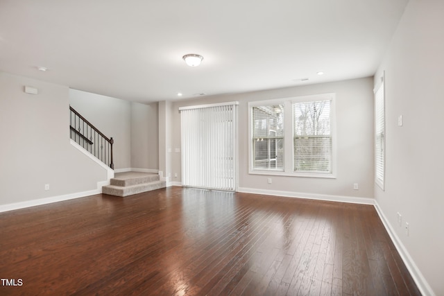 unfurnished living room with recessed lighting, stairway, baseboards, and dark wood-style flooring