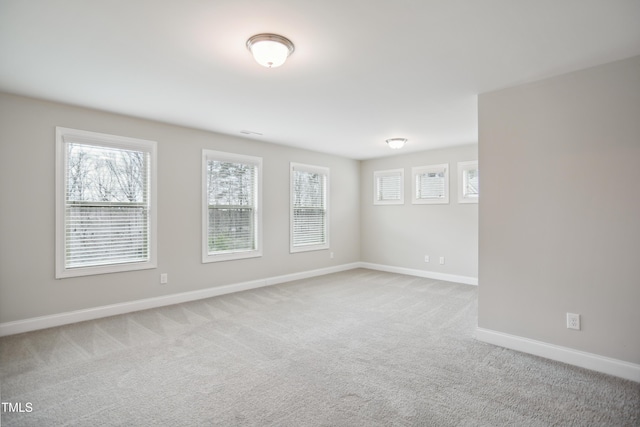 carpeted spare room featuring baseboards