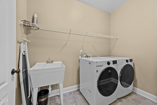 washroom with baseboards, laundry area, and washer and clothes dryer