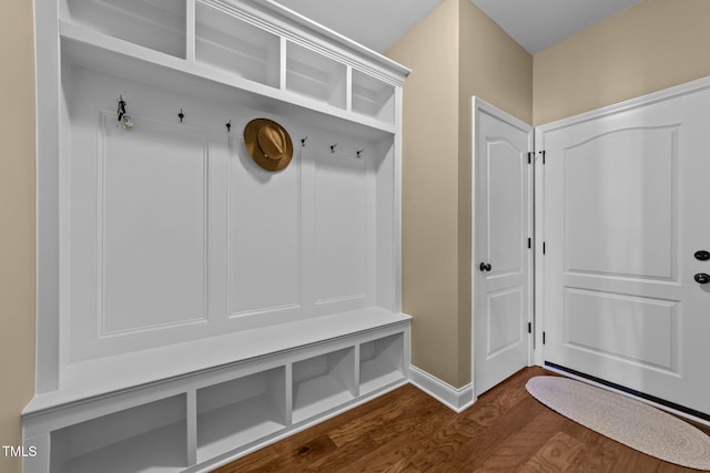 mudroom featuring dark wood-type flooring and baseboards