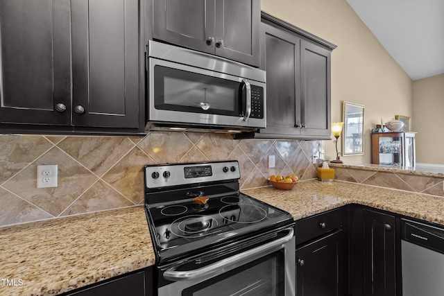 kitchen with decorative backsplash, stainless steel appliances, lofted ceiling, and dark cabinets