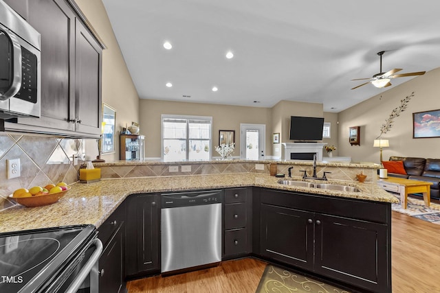 kitchen featuring a sink, ceiling fan, open floor plan, and stainless steel appliances