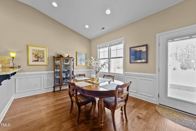 dining space with visible vents, a wainscoted wall, wood finished floors, recessed lighting, and vaulted ceiling