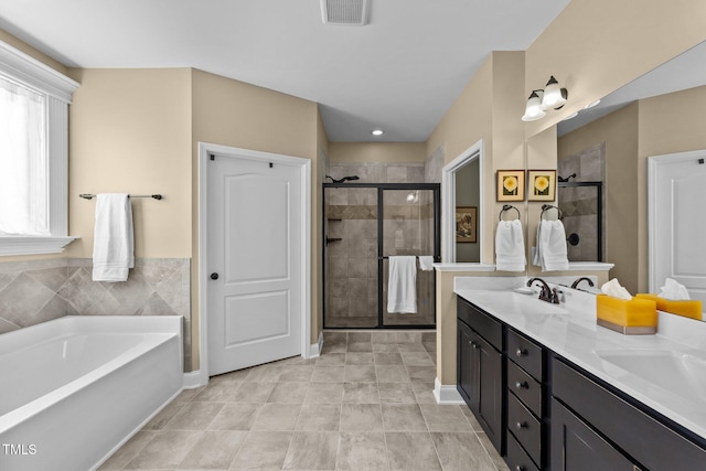 bathroom with visible vents, a sink, a shower stall, double vanity, and a bath