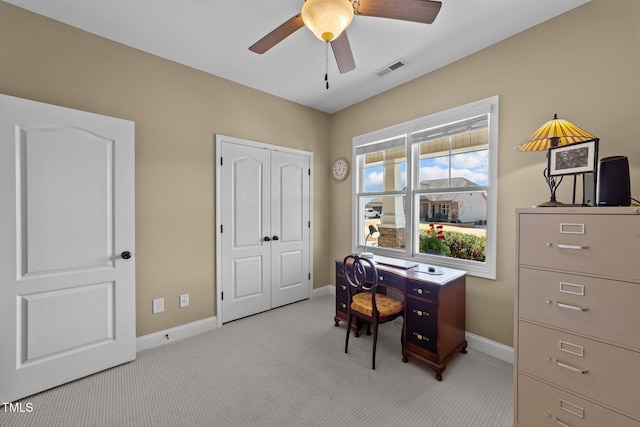 home office with visible vents, light colored carpet, baseboards, and a ceiling fan