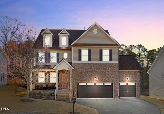 traditional-style house featuring stone siding, a porch, and driveway