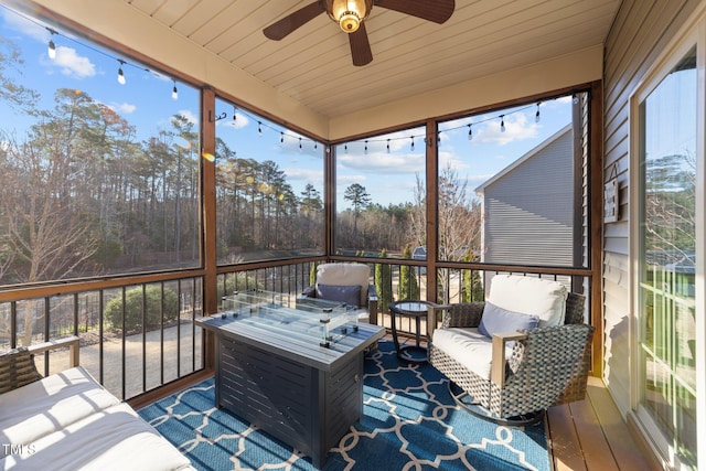 sunroom featuring wood ceiling and a ceiling fan