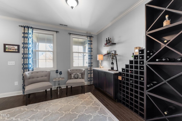 wine area with dark wood-style floors, visible vents, crown molding, and baseboards