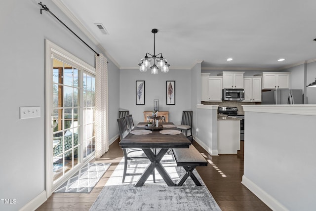 dining space with visible vents, wood finished floors, baseboards, and ornamental molding