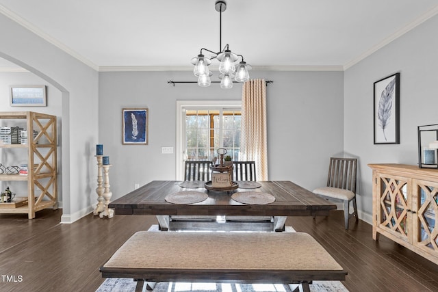 dining room with arched walkways, crown molding, and wood finished floors