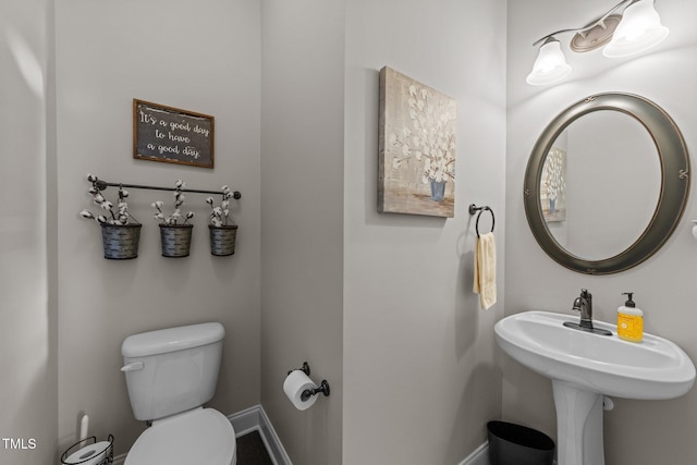 bathroom with toilet and baseboards