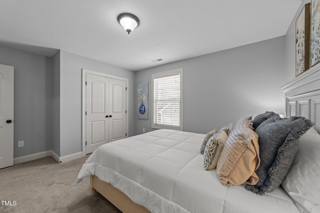 carpeted bedroom with baseboards, visible vents, and a closet