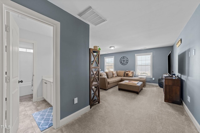 living room featuring baseboards, visible vents, and light carpet