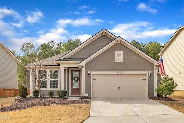 single story home with an attached garage, roof with shingles, driveway, and fence