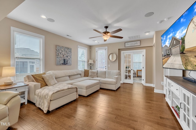 living room with recessed lighting, wood finished floors, visible vents, and french doors