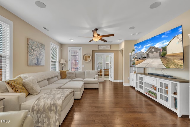 living area with visible vents, a ceiling fan, baseboards, and dark wood-style flooring