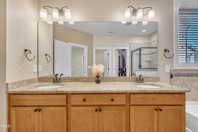 full bath with a shower stall, a garden tub, double vanity, and a sink