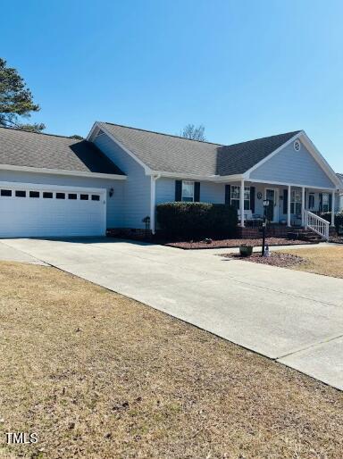 single story home featuring an attached garage, covered porch, and driveway