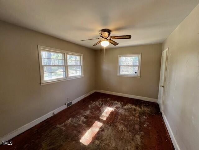 spare room featuring visible vents, a healthy amount of sunlight, and baseboards