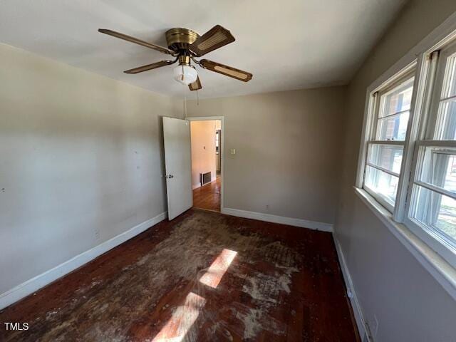 unfurnished bedroom featuring wood finished floors, visible vents, baseboards, and ceiling fan