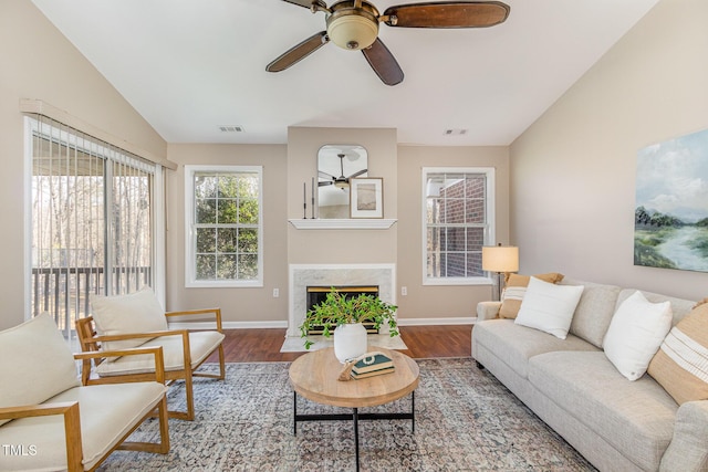 living room featuring visible vents, lofted ceiling, and wood finished floors