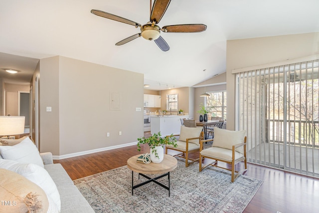 living room with baseboards, lofted ceiling, wood finished floors, and a ceiling fan