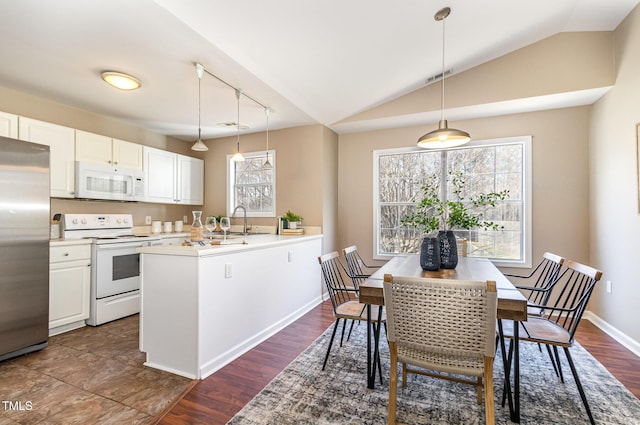 kitchen with visible vents, white cabinetry, white appliances, a peninsula, and lofted ceiling