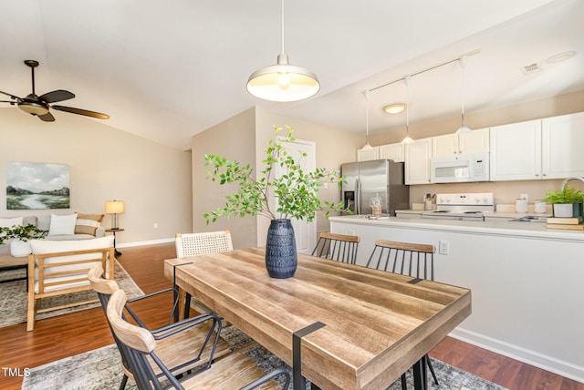 dining area featuring visible vents, wood finished floors, baseboards, ceiling fan, and vaulted ceiling