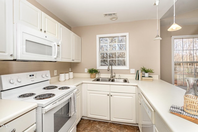 kitchen with white cabinetry, white appliances, visible vents, and a sink