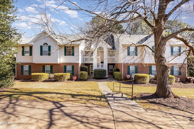 view of front facade featuring brick siding and a front yard