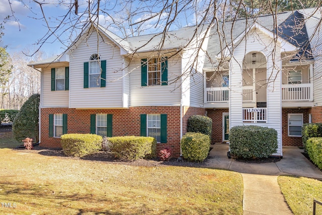 view of front facade featuring brick siding and a front lawn