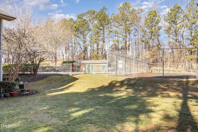 view of yard with a tennis court and fence