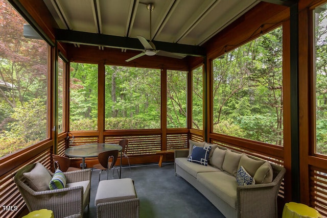 unfurnished sunroom with plenty of natural light, a forest view, and ceiling fan