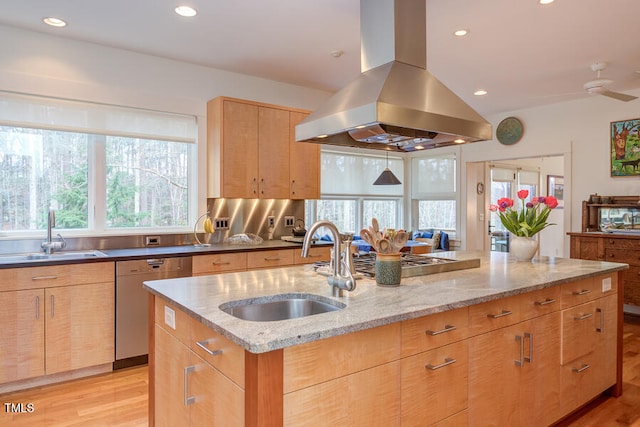 kitchen with dishwashing machine, island exhaust hood, light brown cabinets, and a sink