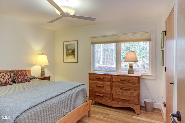 bedroom with ceiling fan, baseboards, and light wood-style floors