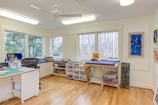 office space featuring light wood finished floors, baseboards, and a ceiling fan