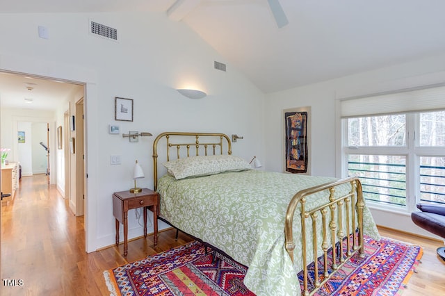 bedroom featuring visible vents, beamed ceiling, baseboards, and wood finished floors