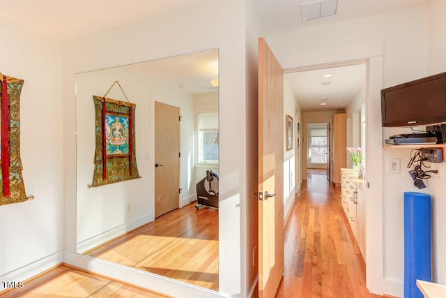 corridor with visible vents and light wood-style flooring