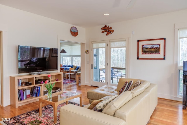 living area featuring recessed lighting, a healthy amount of sunlight, baseboards, and light wood finished floors