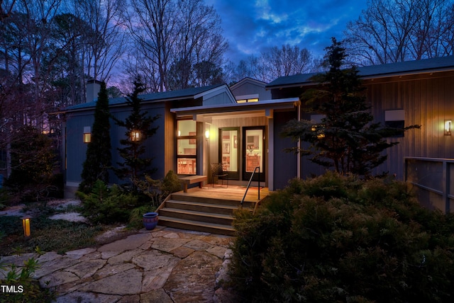 exterior entry at dusk featuring a chimney