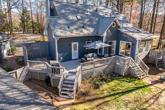 rear view of property featuring a wooden deck, a shingled roof, stairs, a chimney, and outdoor lounge area