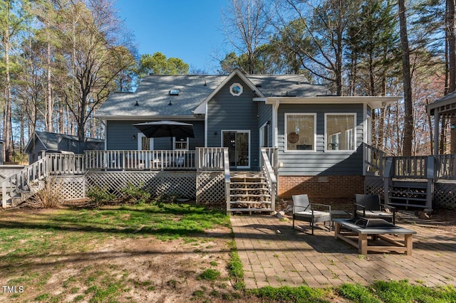 back of house featuring stairway, a lawn, and a wooden deck