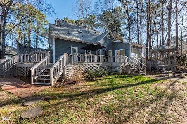 rear view of house featuring a gazebo, a lawn, an outdoor fire pit, and stairs