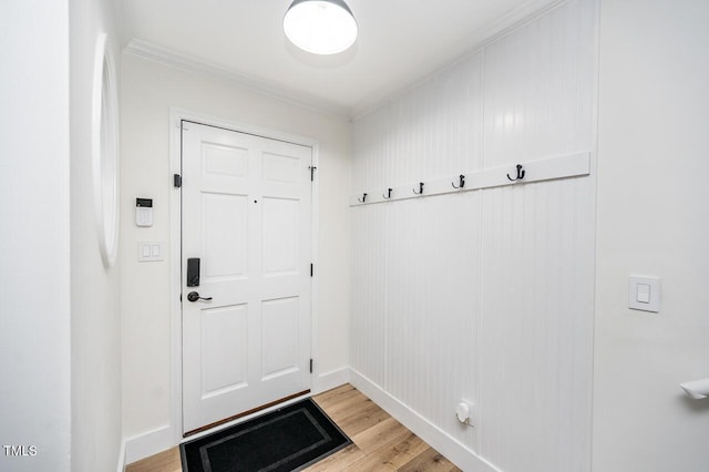 entryway featuring light wood-type flooring, baseboards, and crown molding