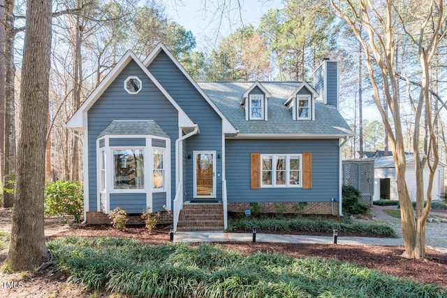 view of front facade featuring entry steps, crawl space, roof with shingles, and a chimney