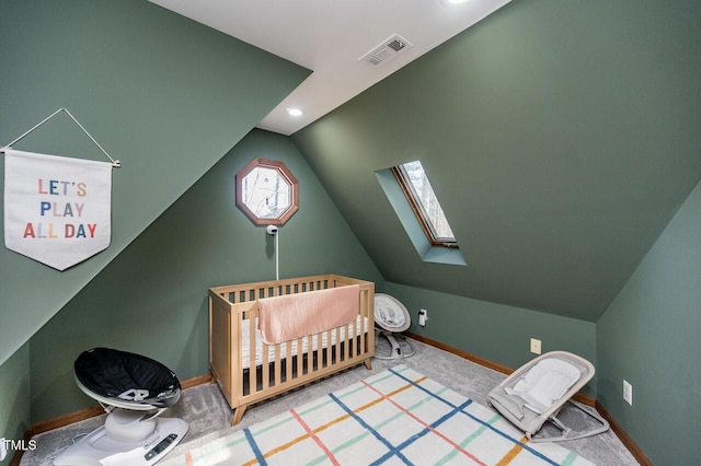 bedroom with visible vents, a crib, lofted ceiling with skylight, carpet floors, and baseboards