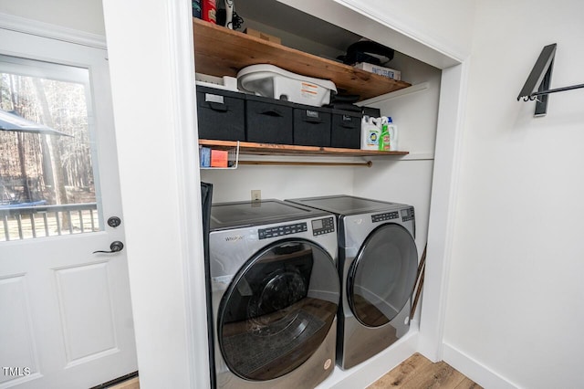 laundry room featuring laundry area, washing machine and dryer, light wood-style floors, and baseboards