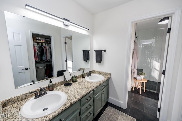 bathroom with double vanity, tile patterned flooring, walk in shower, and a sink