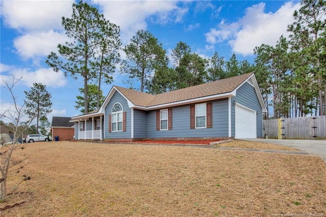 ranch-style home featuring a garage, concrete driveway, a front lawn, and fence